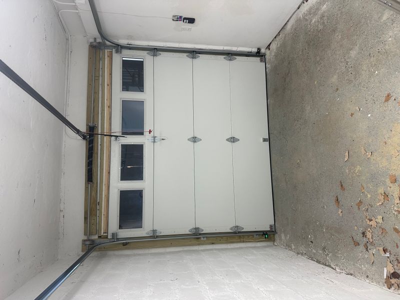 Commercial white sectional door with vertical window inserts interior view